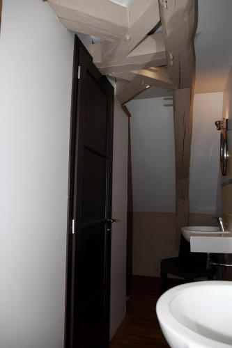 a bathroom with a black door and a sink at Gîte De La Crayère in Gionges