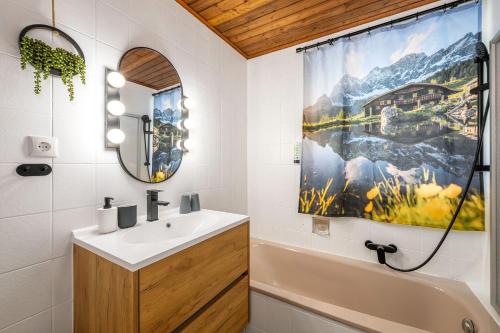 a bathroom with a sink and a shower curtain at Chalet BergMoment - by myNests in Rohrmoos