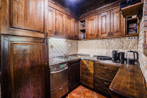 a kitchen with wooden cabinets and a sink at Holiday Home Marta with 4 Bedrooms in Raka