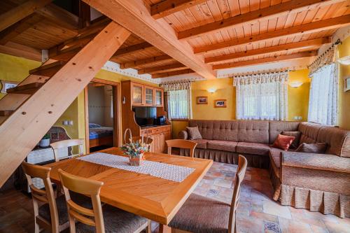 a living room with a wooden table and a couch at Holiday Home Marta with 4 Bedrooms in Raka