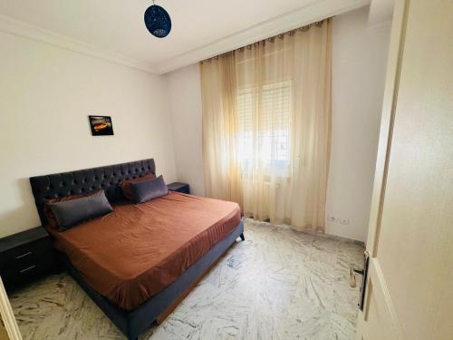 a bedroom with a bed and a window at Eden Cozy Airport in El Aouina Station