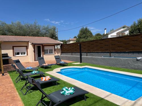 a backyard with a pool and chairs and a fence at TAYP LaParra Homes in La Parra