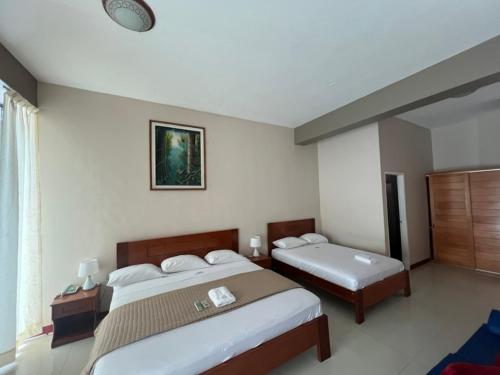a hotel room with two beds and a window at Gran Marañon Hotel in Iquitos