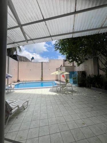 a patio with a swimming pool and an umbrella at Gran Marañon Hotel in Iquitos