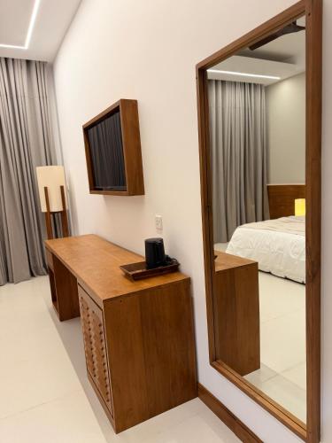 a mirror in a room with a bed and a desk at Oceana Trinco in Trincomalee