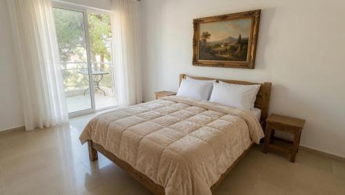 a bedroom with a bed and a painting on the wall at Kineta Prime Suites No8 in Kineta