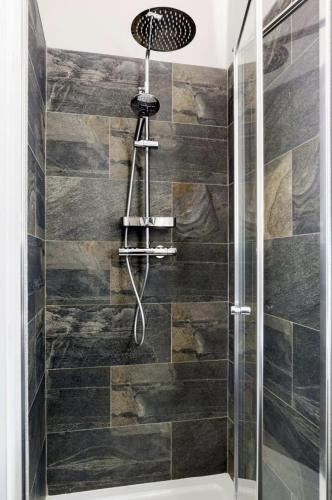 a shower with a shower head in a bathroom at Scandi Lux retreat in Stockholm