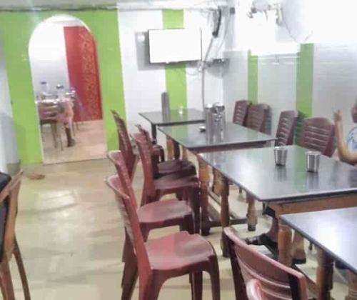 una sala da pranzo con tavoli, sedie e uno specchio di Agate Hotel a Festac Town