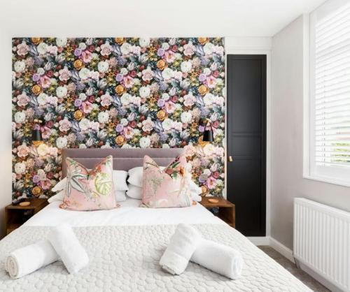 a bedroom with a floral wall behind a bed at Scandi Lux retreat in Stockholm