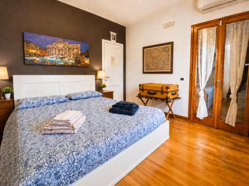 a bedroom with a bed with a blue comforter at Villa Domus Roma in Rome