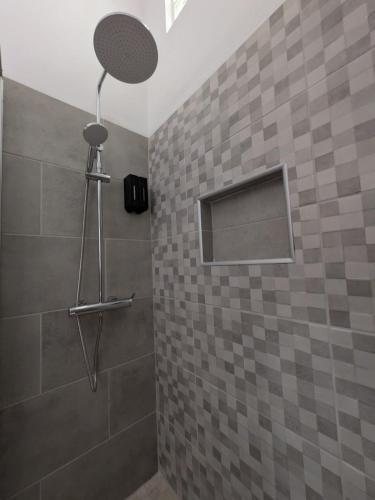 a bathroom with a shower with a tiled wall at Casa Crisel in Aljezur