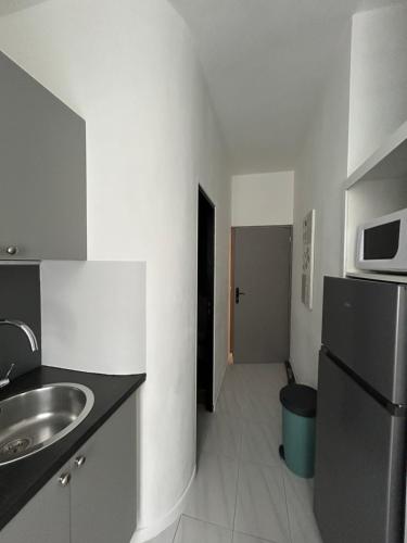 a small kitchen with a sink and a microwave at Charmant T2 centre ville in Givet