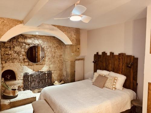 a bedroom with a bed and a stone wall at La Chaumière, centre historique, fibre, ESS, rez-de-chaussée, BedinShop in Romans-sur-Isère