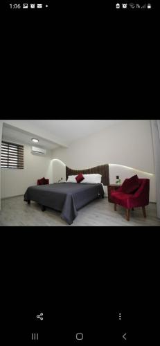 a bedroom with a bed and a red chair at Lailinn Serenity in Santa Cruz Xoxocotlán