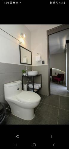 a bathroom with a white toilet and a sink at Lailinn Serenity in Santa Cruz Xoxocotlán