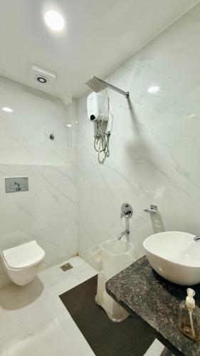 a white bathroom with a sink and a toilet at Hotel Shree Banke Bihari Heritage in Maheshwar