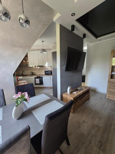 a living room with a dining table and a kitchen at Eleganckie Lokum in Malbork