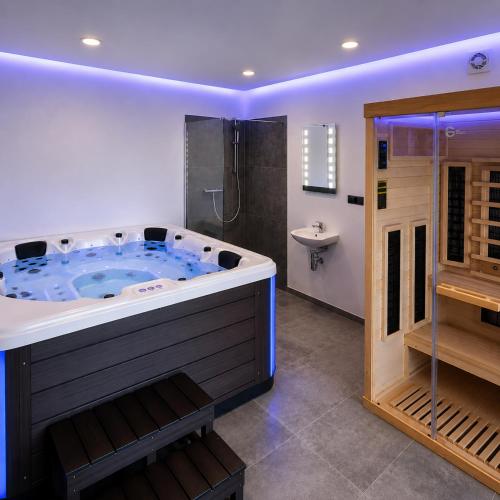a large bathroom with a large tub and a sink at Grafitowe Apartamenty in Czarna Góra