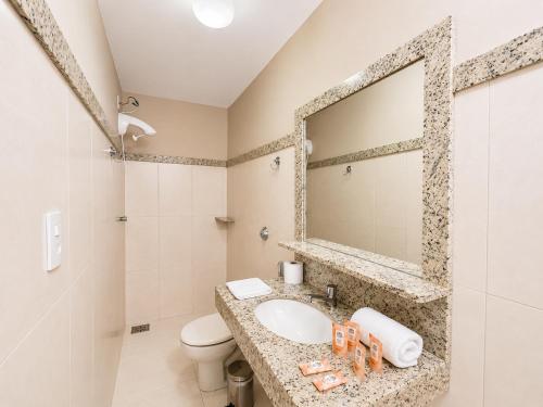 a bathroom with a sink and a mirror at Vila da Praça Pousada in Capitólio