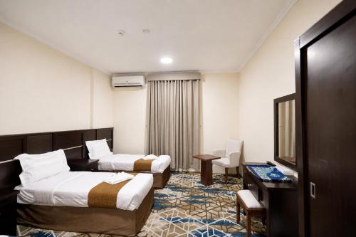 a hotel room with two beds and a television at Sama Al Bayt in Mecca