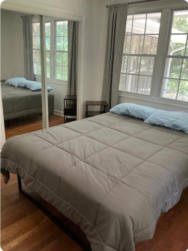 a bedroom with a large bed and two windows at Bankston House B&C in Marietta