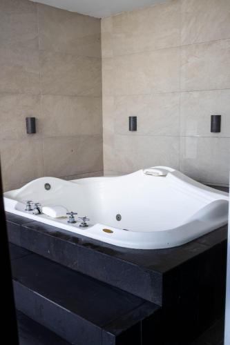 a large white bath tub sitting in a bathroom at Hotel Costa Verde in Veracruz