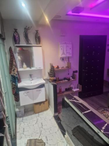 a room with a sink and a door with purple lights at apparemment wifaq in Temara