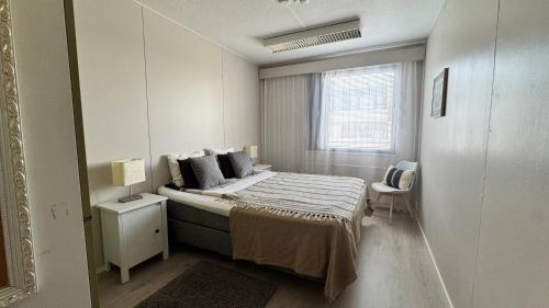 a white bedroom with a bed and a window at Scandinavian Dream Guesthouse and Apartments in Rovaniemi