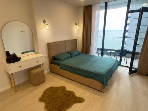 a bedroom with a bed and a dresser and a mirror at Paradise Apartments Solis in Batumi