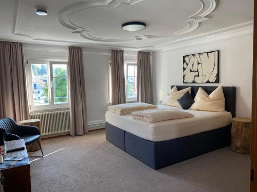 a bedroom with a large bed in a room with windows at Goldener Adler 