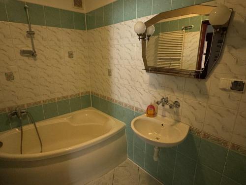 a bathroom with a tub and a sink at Dom Wypoczynkowy U Kasi in Jurgów