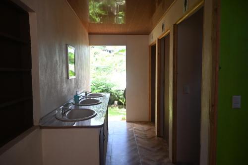 a bathroom with three sinks and a window at Hostel Mar y Bosque in Drake