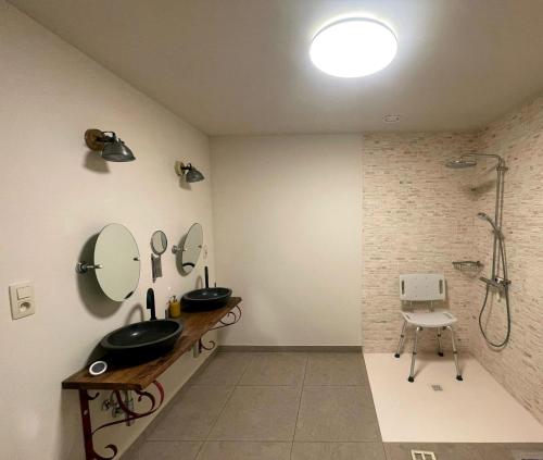 a bathroom with two sinks and a shower at Maison Campagnard in Voeren