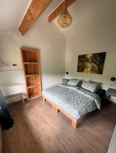 a bedroom with a bed and a painting on the wall at Maison Campagnard in Voeren