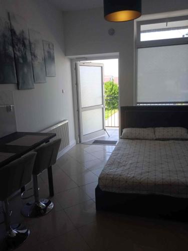 a bedroom with a bed and a sliding glass door at Lunar Apartament in Augustów