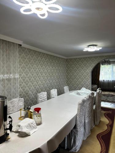 a dining room with a white table and chairs at Guest House Sveta in Saty