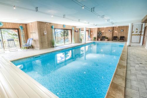 - une grande piscine d'eau bleue dans une maison dans l'établissement Résidence Le Tyrol, à La Rosière