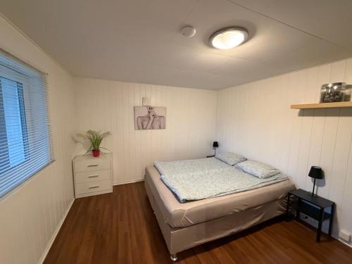 a bedroom with a bed and a dresser in it at Sukkertoppen Apartment in Ålesund