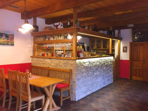 Řetová的住宿－Pension Mandl，餐厅内的酒吧配有木桌和椅子