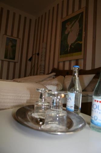 a tray with glasses and bottles on a table next to a bed at Tallhöjden Hotel & Cottage Lodge in Simlångsdalen