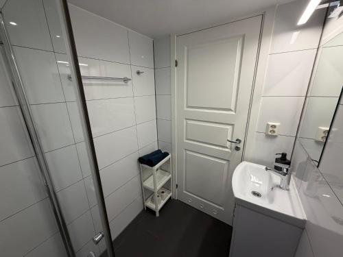 a white bathroom with a sink and a mirror at Sukkertoppen Apartment in Ålesund