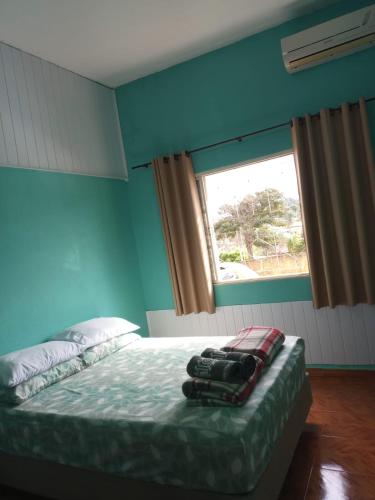 a bedroom with a large bed with a window at Suíte Gigá 1 in Brotas