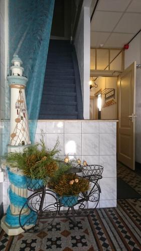 a table in a room with a lighthouse and a staircase at Hotel De Ruyter in Vlissingen
