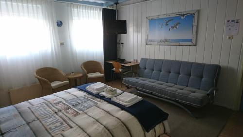 a hotel room with a bed and a couch at Hotel De Ruyter in Vlissingen