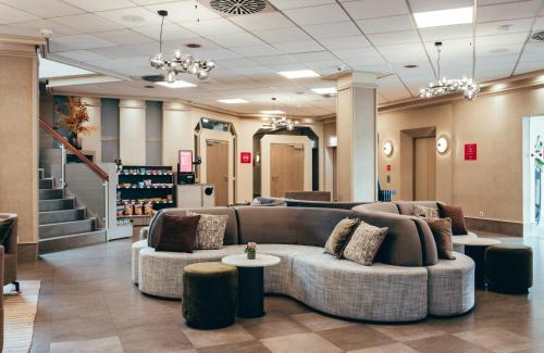 a lobby with couches and tables in a store at Leonardo Hotel Köln in Cologne