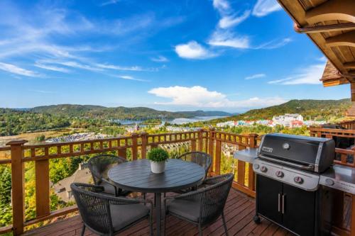 a patio with a table and chairs on a deck at Tremblant Prestige - Altitude 172-11 in Mont-Tremblant