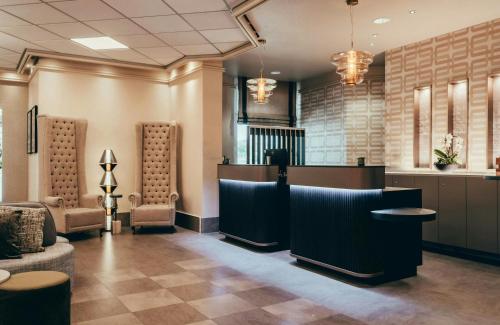 a lobby with a waiting room with a reception desk at Leonardo Hotel Köln in Cologne