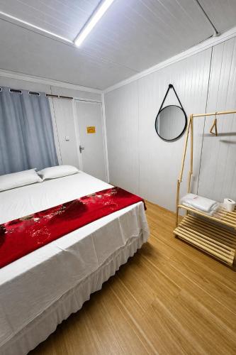 a bedroom with a large bed with a red blanket at Pousada Villa Sítio in Campina Grande