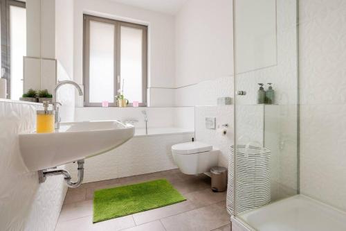 a white bathroom with a sink and a toilet at Helenas place in Berlin