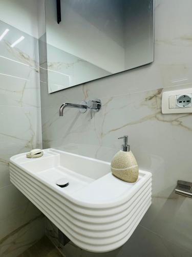 a bathroom with a white sink and a mirror at TBS House in Alghero